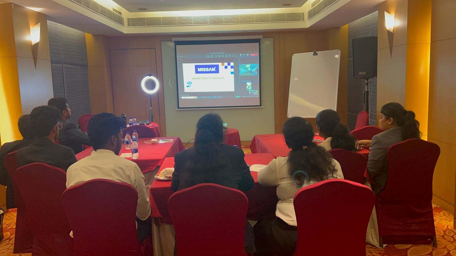 Missan's India team, seen from behind, watching a Missan brand and values presentation on a projector screen