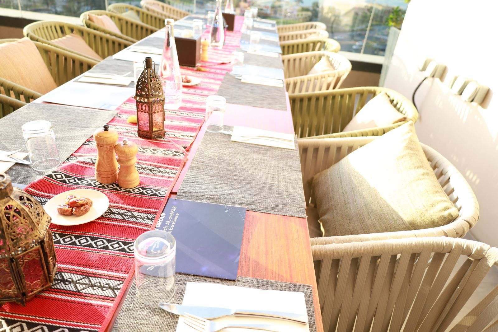 Lanterns, dates and a Missan Group brochure on a long table set with a red sadu runner