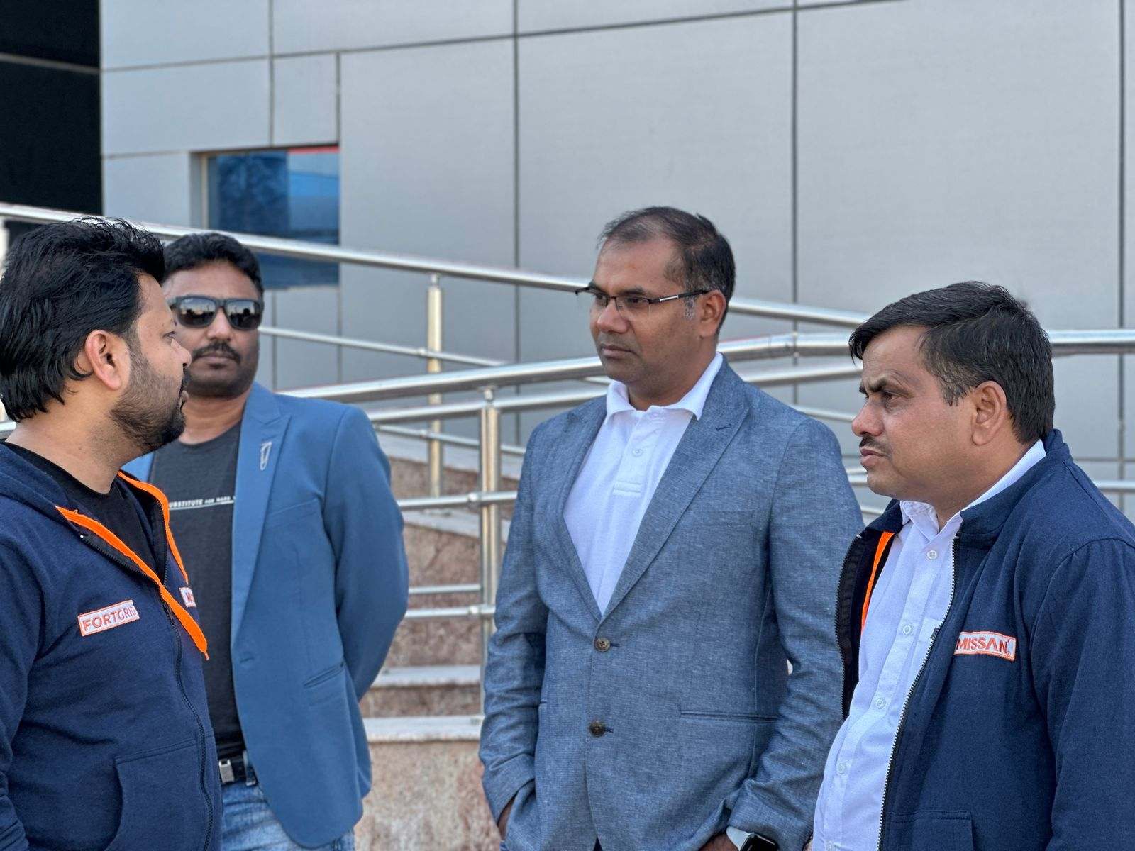 Four Missan staff in conversation outdoors, two in Missan and FortGrid branded jackets